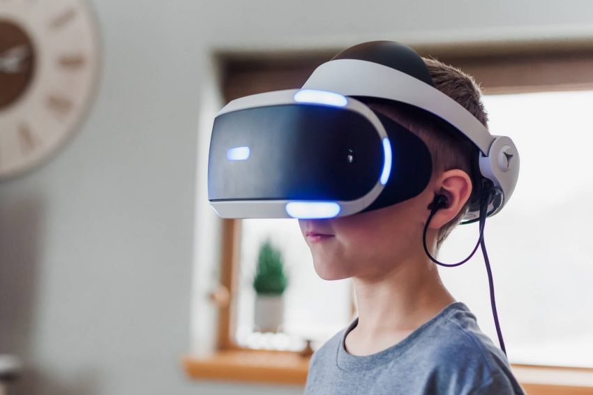 A child enthusiastically wearing an augmented reality headset, immersed in a digital world.